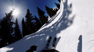 Skiër-POV vanaf een besneeuwde helling met dennenbomen en zon, een met AI gemaakt voorbeeldfilmpje